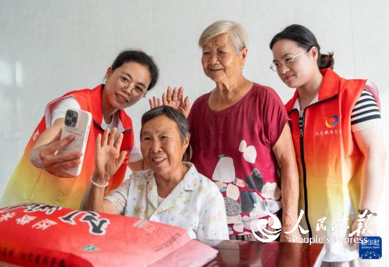 10月5日,江苏省南通市通州区金新街道界北村志愿者帮助老人与远在海外的子女进行视频通话,“云端”相聚,共迎中秋。 新华社发(翟慧勇摄)