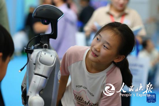 10月2日,在山东省第九届滕州书展现场,小朋友与机器人互动。 新华社发(李志军摄)