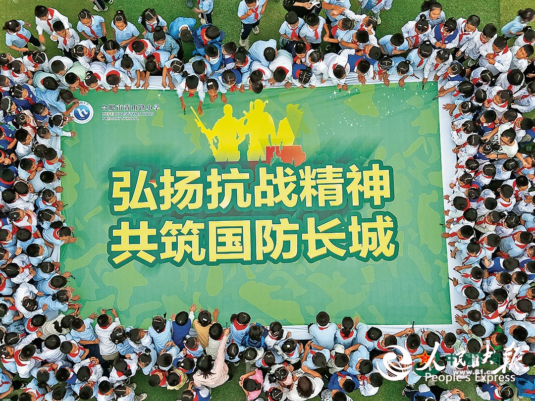 安徽省合肥市蜀山区人武部联合当地学校开展国防教育进校园活动。图为学生们在国防教育主题海报上签名。葛宜年摄